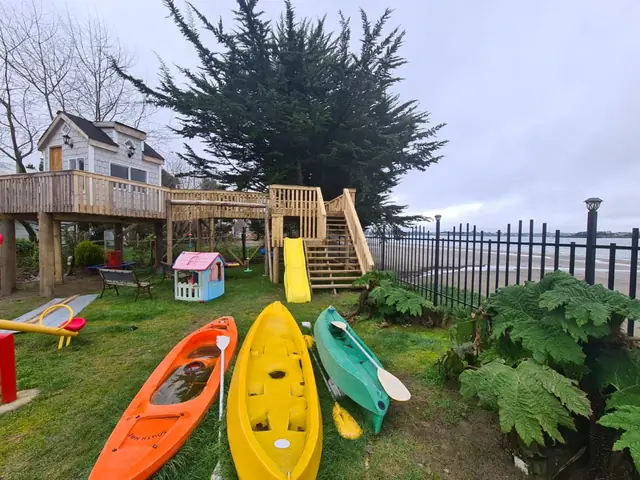 Zona de juegos, casa del árbol y kayaks en el jardín, frente a la playa