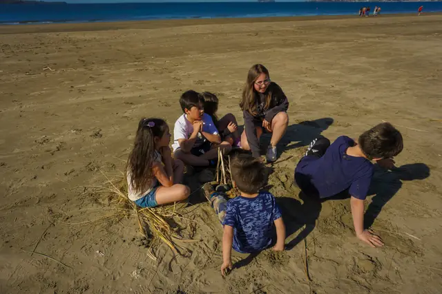 Niños jugando en la arena de Playa Lechagua, frente a las cabañas