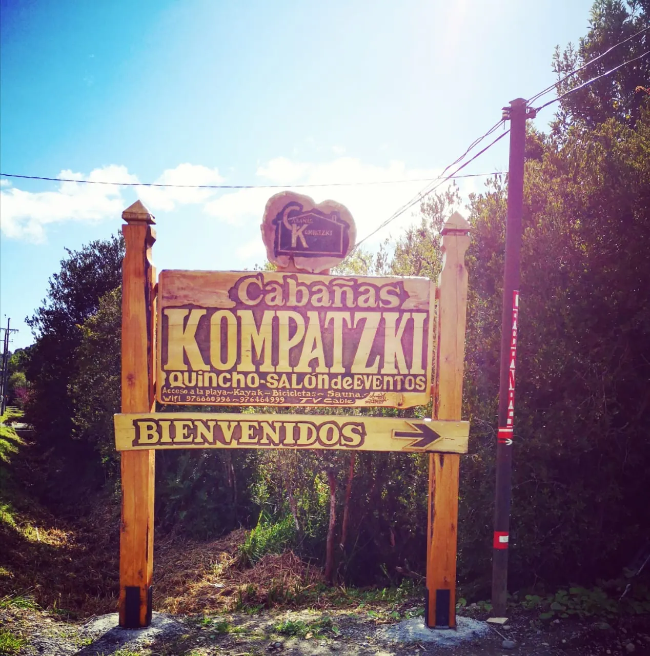 Letrero de madera de Cabañas Kompatzki en la entrada, con la palabra Bienvenidos