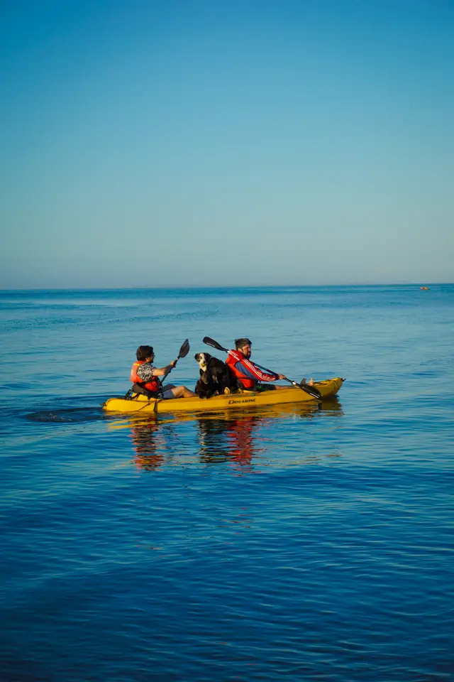 Kayak sobre el mar en calma frente a Playa Lechagua al atardecer, Ancud