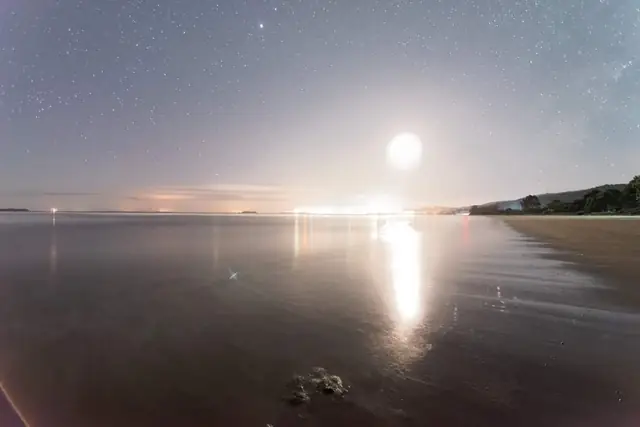 Playa Lechagua de noche con la luna reflejada sobre el mar