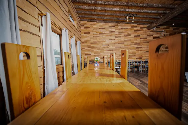 Mesas largas de madera dispuestas para un evento en el salón de Cabañas Kompatzki