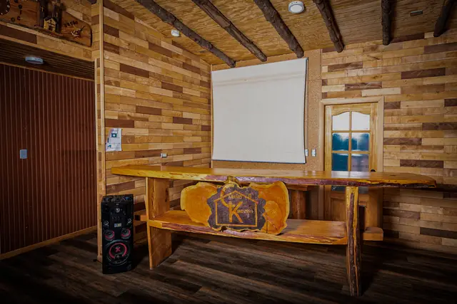 Barra de madera con el logo tallado de Kompatzki, telón de proyección y equipo de sonido