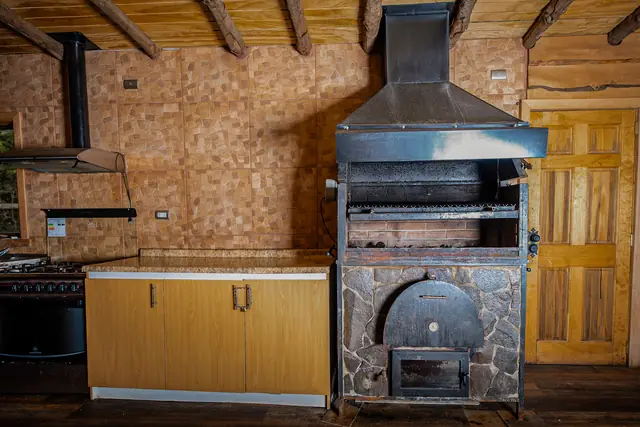 Cocina del salón de eventos con horno de barro y encimera