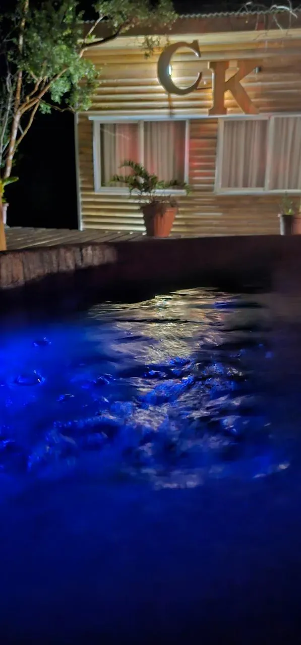 Agua de la tinaja iluminada en azul con el reflejo de la luz del deck