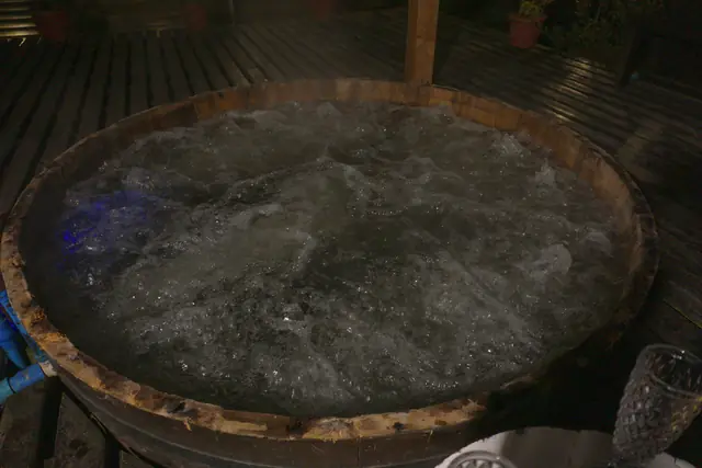 Tinaja de agua caliente burbujeando de noche en Cabañas Kompatzki